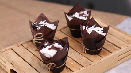 catherine chocolate cake wrapped in brown cake paper and tied with hemp rope, arranged on a hollow...