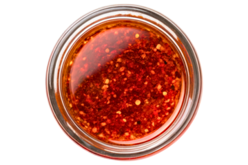 Red spicy oil in a glass jar from above isolated with transparent background