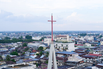 Skyline of Pontianak city reflecting its ethnic and religious diversity, marked by a church steeple...