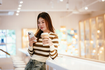 A young woman wearing headphones and glasses, appearing to be an East Asian female, intently uses a...