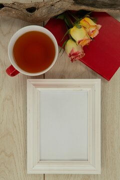 Fototapeta Photo frame, lemon tea, diary and flowers on wooden table