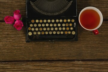Typewriter, flowers and lemon tea on table