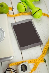 High angle view of digital tablet and tape measure