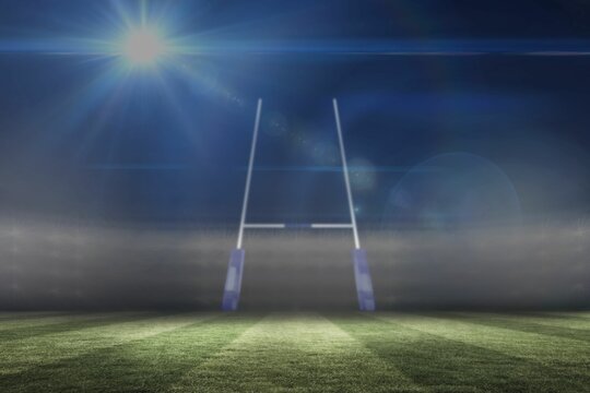 Flat design rugby goalposts are standing on green grass pitch under stadium floodlights at night