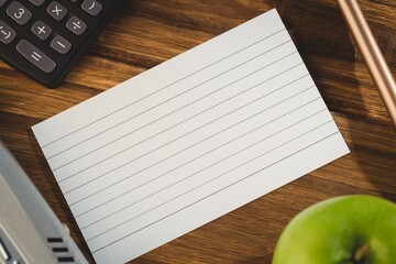 Paper and pen with apple by calculator