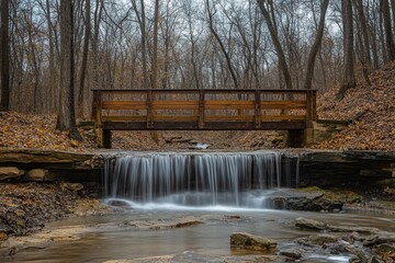 Wooden bridge spans a serene waterfall in tranquil wooded area during autumn, Wooden bridge and a waterfall in the woods
