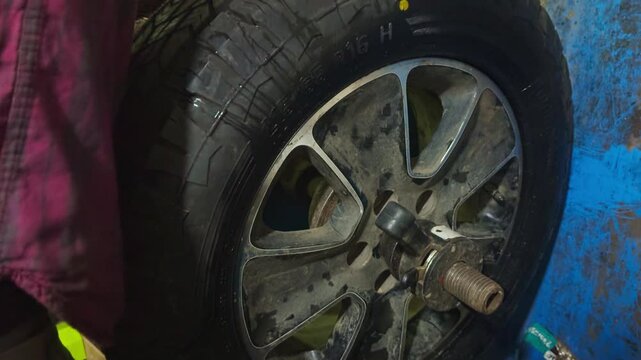 Mechanic checks rim alignment using balancing machine