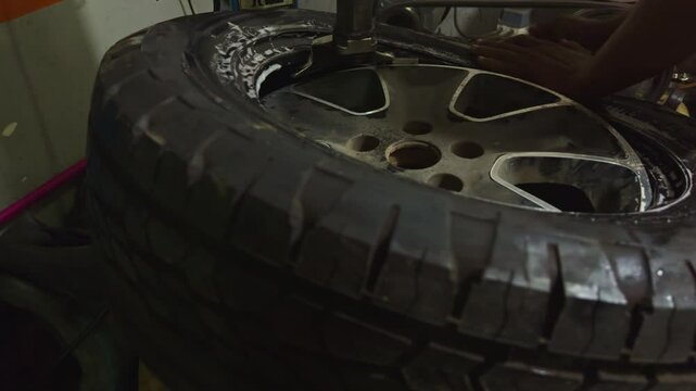 Mechanic install new tyre onto metal rim with precision