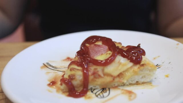 pouring tomato sauce onto a pizza, pizza knife cutting slice of cheesy pizza on a plate, close-up view of delicious freshly baked pizza during a casual mea
