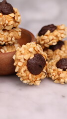 Cheese Peanut Chocolate in the photo on a marble table and small wooden bowl and mesh pan