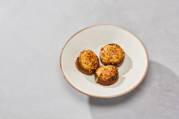 Baked champignon mushrooms with cheese, minimal composition, soft natural lighting, simple white...