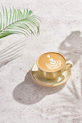 Cappuccino with leaf latte art, bright natural lighting, minimal overhead composition