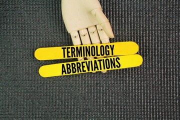 Yellow wood with the words terminology and abbreviations. Terminology refers to the specific vocabulary used within a particular field or subject, while abbreviations are shortened forms of words