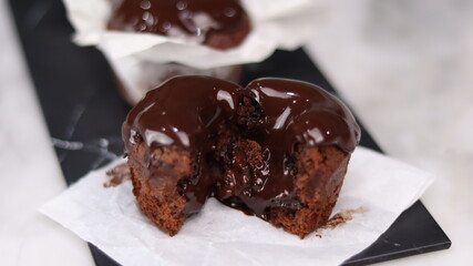 chocolate cake wrapped in cake paper with chocolate glaze topping