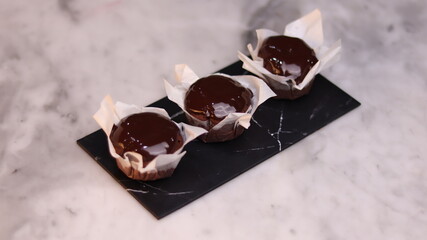 chocolate cake wrapped in cake paper with chocolate glaze topping