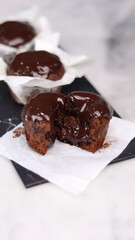 chocolate cake wrapped in cake paper with chocolate glaze topping