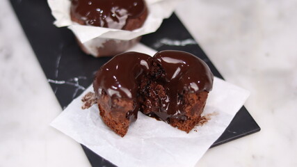 chocolate cake wrapped in cake paper with chocolate glaze topping