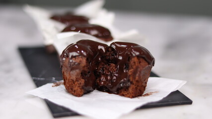 chocolate cake wrapped in cake paper with chocolate glaze topping