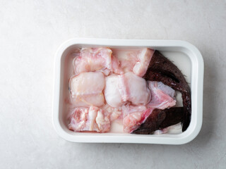 Raw monkfish cut into pieces on a plate