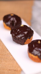 three cakes with frosted and gold chocolate topping and crunchy chocolate filling