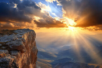 Cliffside view of mountains and valley with sun rays piercing through clouds