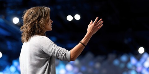 dynamic angle photo of woman giving work presentation on stage