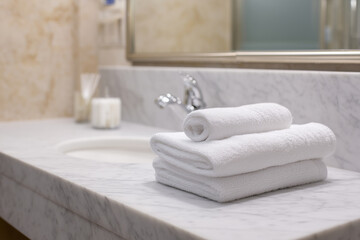 close-up of luxury hotel bathroom with marble textures and folded towels