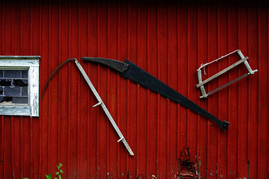 Traditional Farm Tools on a Red Finnish Barn Wall