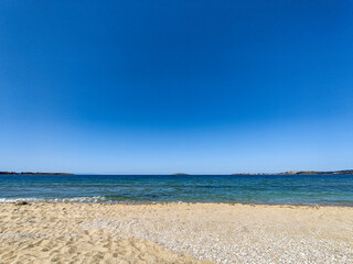 Beach, sea, empty sky and island in the distance