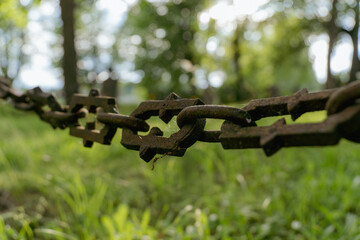 Rustic Iron Chain with Cross Motif in Forest Cemetery – Symbol of Memory and Respect