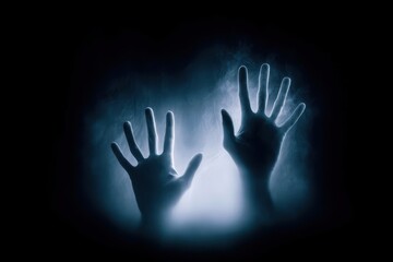 A pair of hands are shown in a dark room with a blue light shining on them
