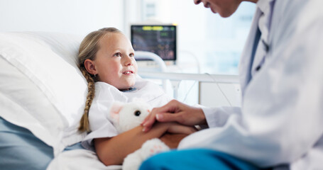 Holding hands, doctor and child on bed in hospital for healthcare medicine, support and trust. Pediatrician, kid or patient with teddy bear at pediatrics clinic for help, empathy or comfort in ward