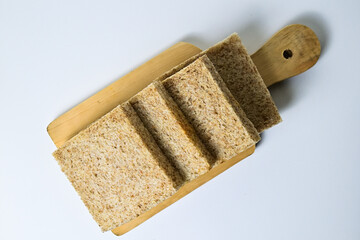 Top view of whole wheat sliced bread on wooden cutting boardd with abstract product background. Isolated on white. Clipping path. high angle, above.