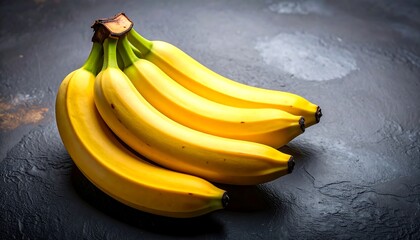 A Bunch of Ripe Yellow Bananas on a Dark Surface