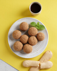 Tiramisu Flavored Chocolate Truffle Pralines on yellow background , Sweet Mini Balls for Snacks. top view