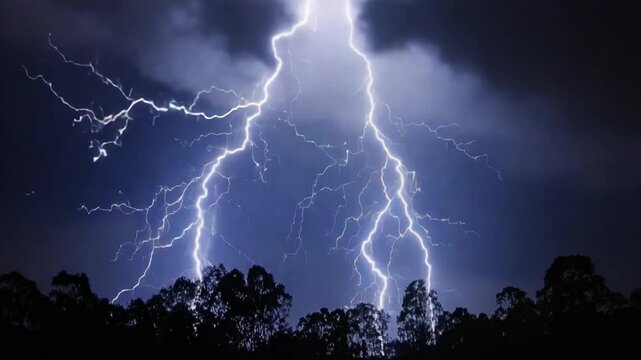 Spectacular lightning strikes illuminating the night sky over a tree line, showcasing nature's raw power and beauty