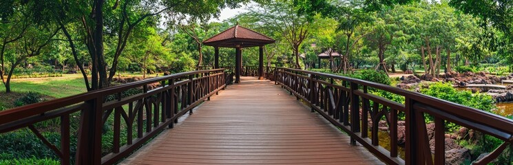 Obraz premium Wooden bridge path through lush park