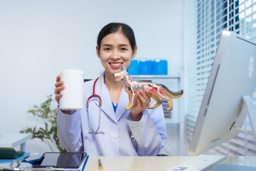 A confident Asian female veterinarian sits at her desk, providing online consultations. She uses...