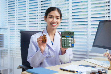 A confident Asian female veterinarian sits at her desk, calculating pet care costs using a...