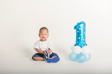 Happy First Birthday Celebration With a Cheerful Toddler and Blue Balloon Decoration