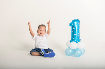 Happy First Birthday Celebration With a Cheerful Toddler and Blue Balloon Decoration