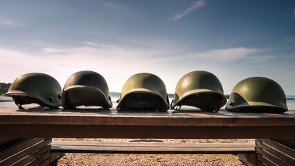 Naklejka premium Military helmets lined up on a wooden table