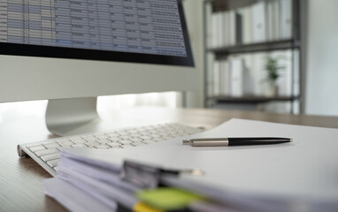 Documents graph Analyze document plans modern office workspace with computer monitor displaying spreadsheets, keyboard, pen, and stacks of paper