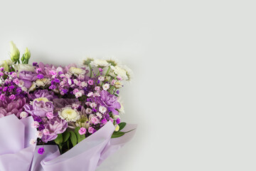 Bouquet of different purple flowers as a gift, white background. Gift for a holiday, Women's Day, Wedding, Mother's Day, March 8.