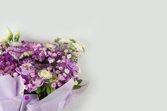 Bouquet of different purple flowers as a gift, white background. Gift for a holiday, Women's Day, Wedding, Mother's Day, March 8. - Powered by Adobe