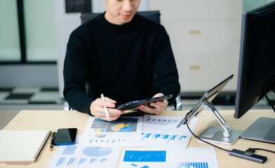 Asian designer’s hands reviewing UX/UI mockups and color palettes at modern desk. App design,...