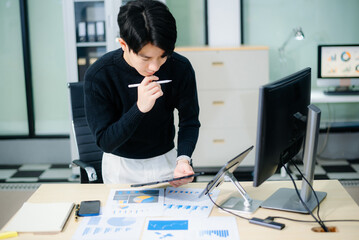 Asian designer’s hands reviewing UX/UI mockups and color palettes at modern desk. App design,...