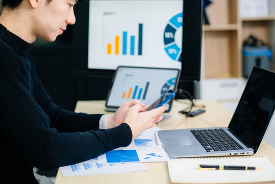 Closeup of young Asian professional analyzing business charts on a tablet with stylus. Concept of data analysis, financial reporting