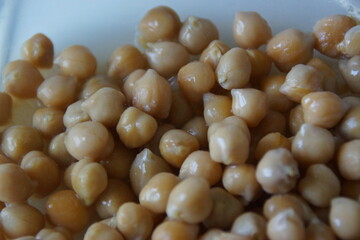 A close-up of golden-hued dried chickpeas, artfully arranged to highlight their rustic texture and...