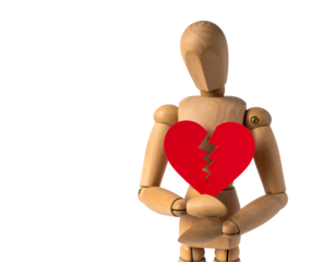 Wooden mannequin holds a broken red heart, symbolizing heartbreak and emotional pain.